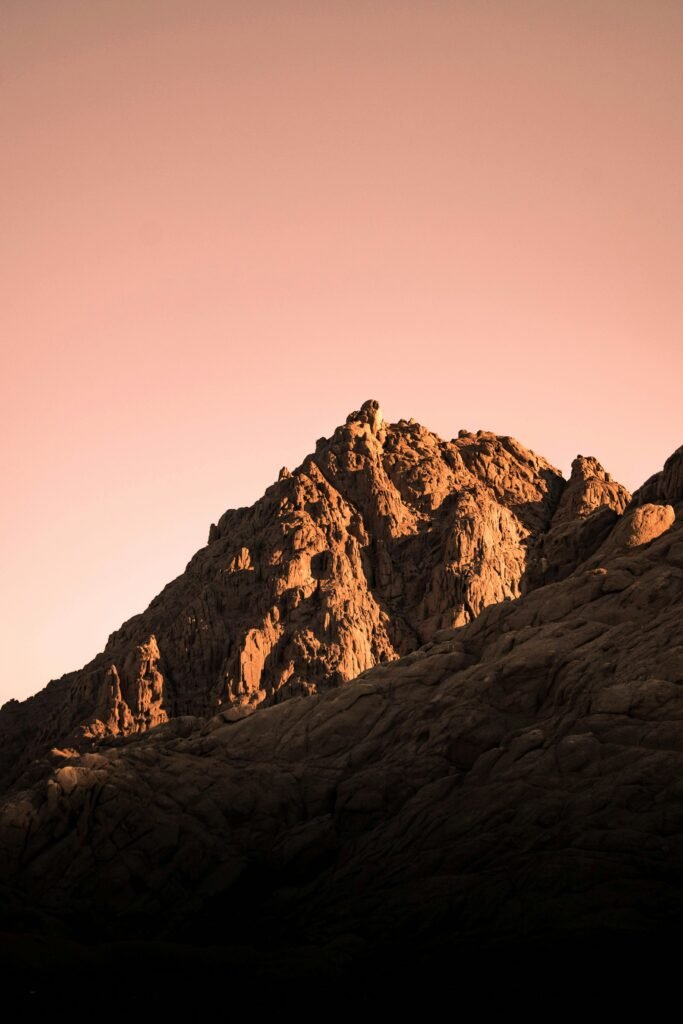 Stunning sunset view of rugged mountains in Sharm El-Sheikh, Egypt, casting warm golden hues.