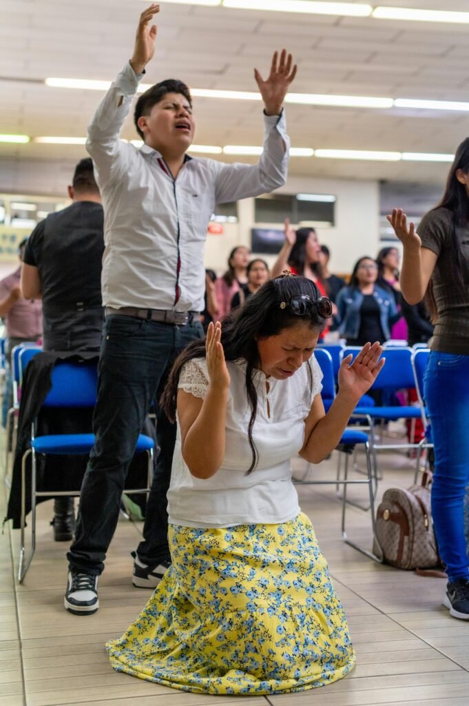A diverse group worships with passion, capturing unity and faith in action.