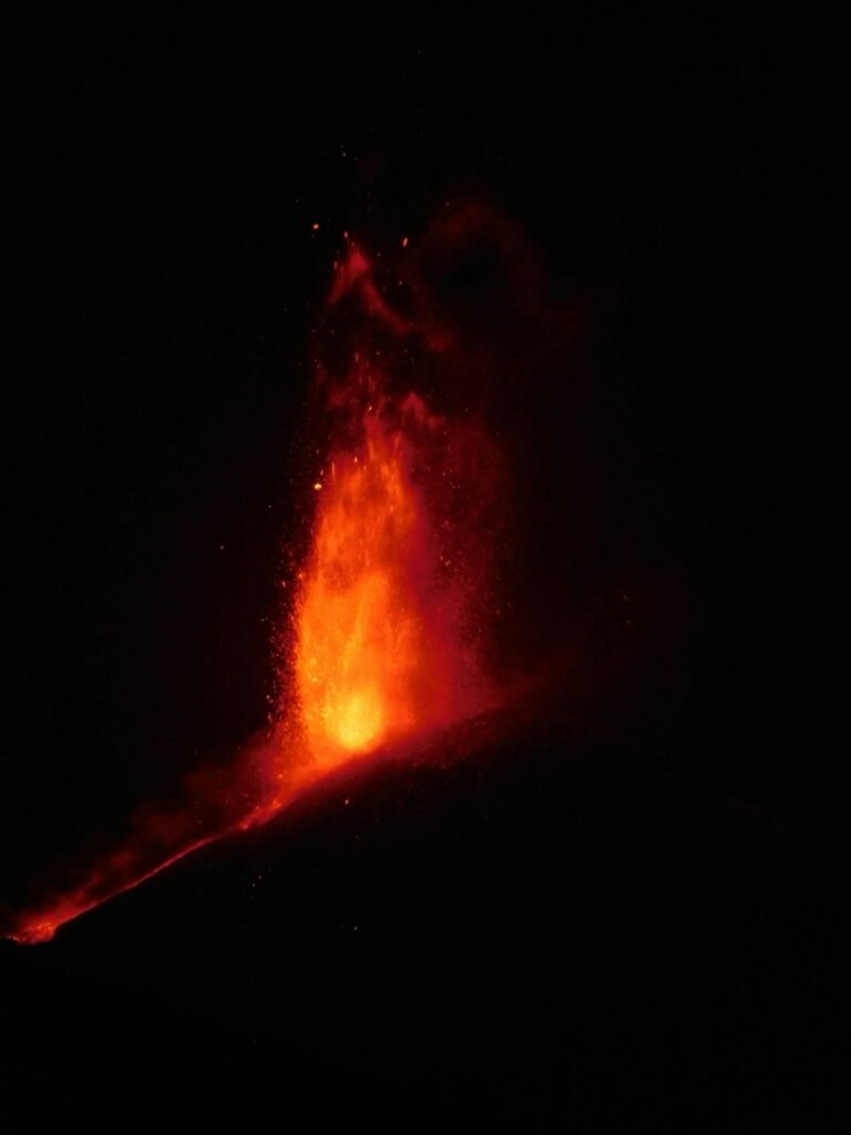 Stunning view of a fiery volcano eruption against a dark background, showcasing nature's power and beauty.