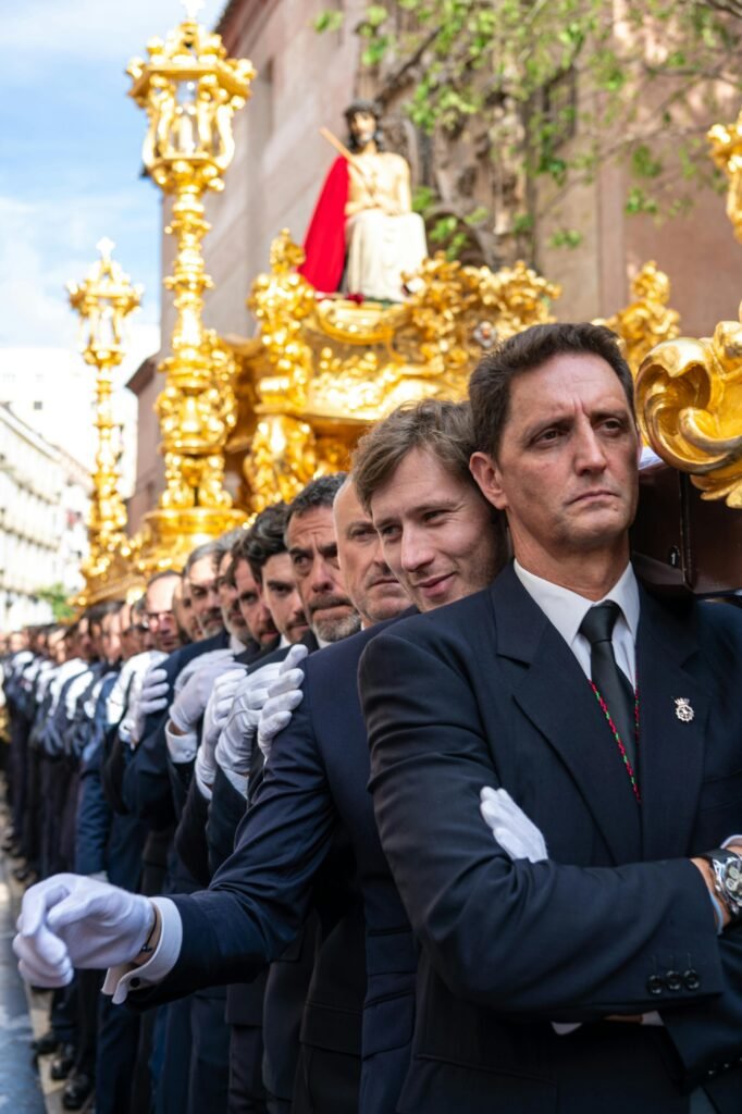 Men in suits carry a religious float during an Easter procession in Málaga, Spain.
