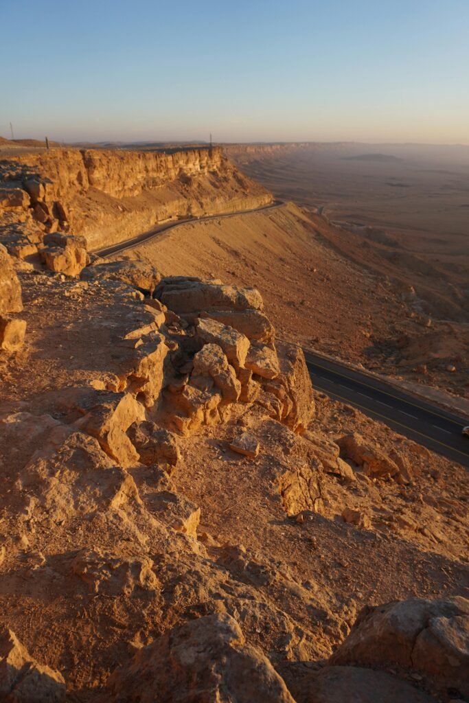 A breathtaking view of Mitzpe Ramon crater showcasing the rugged desert landscape and winding road.